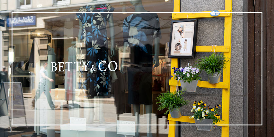 Schaufenster des neuen Betty Barclay Stores in der Max-Eyth-Straße Kirchheim mit Logo ‚BETTY & CO‘ und gelber Leiter mit Blumen.