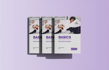 Mockup eines Bantlin-Prospekts mit dem Titel "Basics - Mode die Sie im Alltag trägt Herbst/Winter 2025" auf lilafarbenem Hintergrund, Cover mit zwei Models in weißer Kleidung.