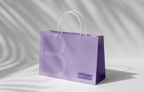 Mockup einer lilafarbenen Bantlin-Einkaufstasche mit großer Bantlin Bildmarke B und Logoaufdruck, weiße Henkel, auf hellem Hintergrund.
