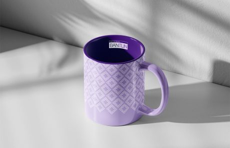 Mockup einer lilafarbenen Kaffeetasse mit Bantlin-Logo und grafischem Brand-Muster, auf hellem Hintergrund.